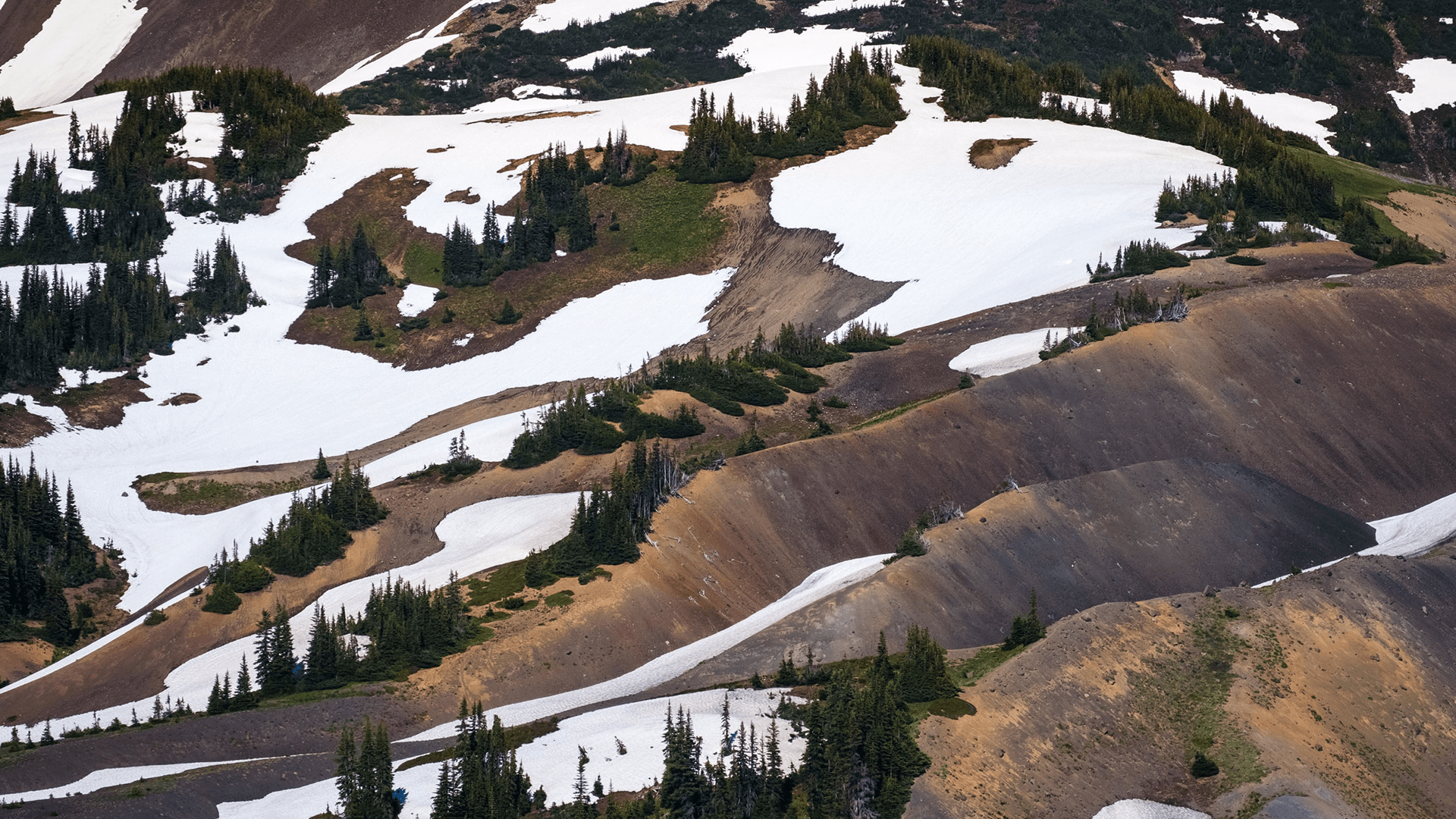 Layered foothills covered in melting snow